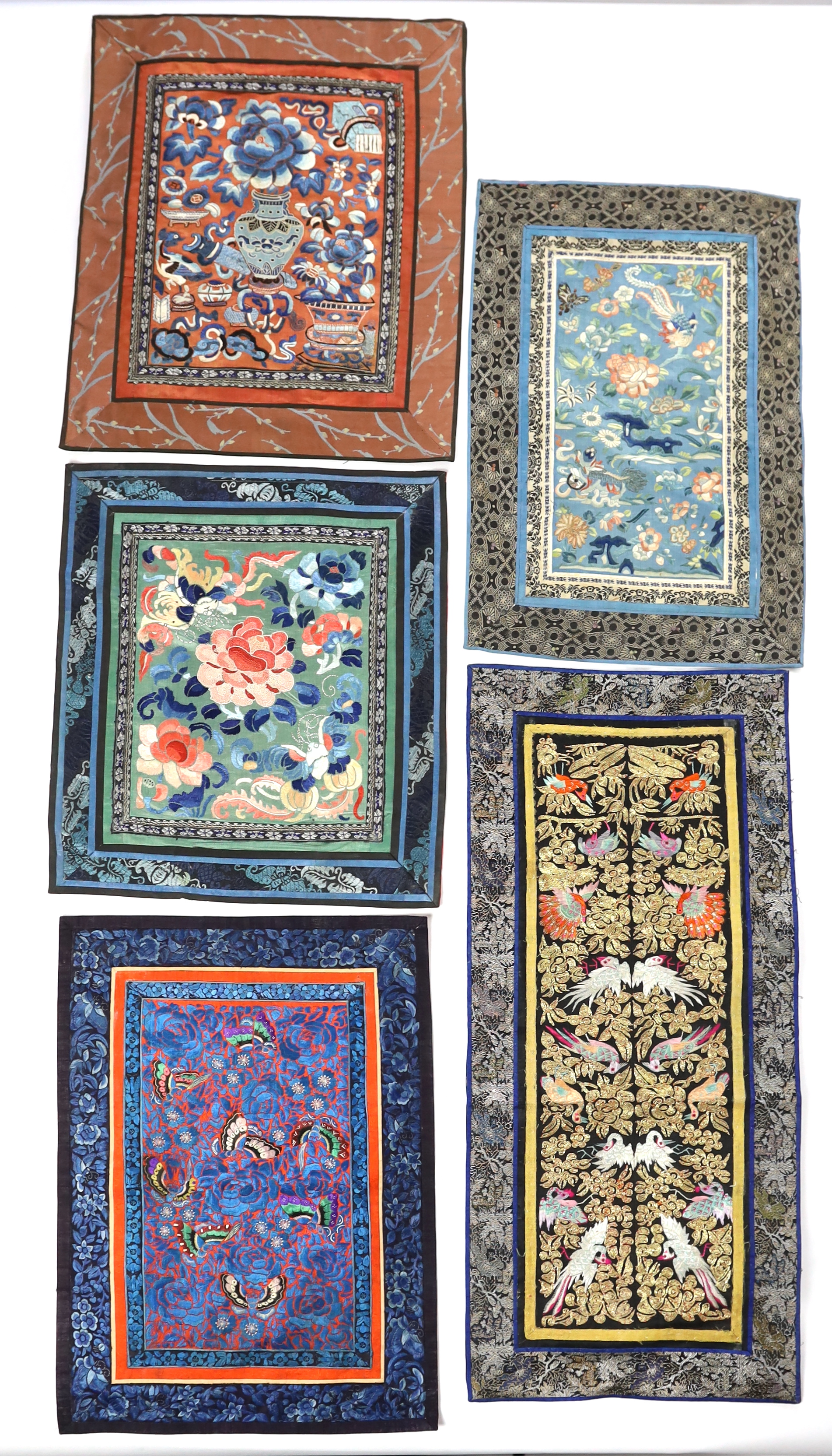 Five Chinese late Qing dynasty silk embroidered panels, two being embroidered with Beijing knot, a pair of metallic embroidered with phoenix sleeve bands, the other embroidered with butterflies and flowers, all five pane